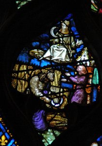 Das Westrosenfenster zeigt eine Szene aus dem Buch der Offenbarung: Zeit der Ernte. Menschensohn mit einer Sichel auf einer weißen Wolke (beachten Sie das venezianische Glas in den roten und weißen Spiralen der Säule).