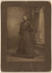 Porträt einer jungen Frau im langen schwarzen Kleid, stehend von George W. Killian