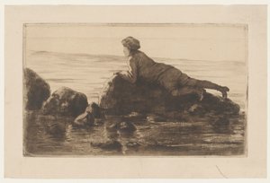 Junge, der auf Felsen am Strand liegt