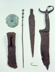Von oben nach unten: Messer, Speerspitze, Angelhaken, Wäscheklammer, Gürtelplatte und Axt, alle gefunden in Männergräbern in Hallstatt, Eisenzeit