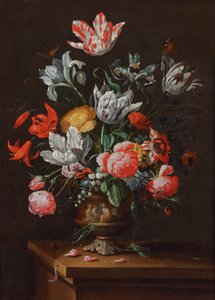Tulpen und andere Blumen in einer bemalten barocken Steingutvase auf einem Holzvorsprung