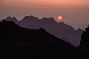 Eine brillante karminrote, orangefarbene Sonne geht über dem Yan Shan-Gebirge unter. Shanhaiguan-Pass, H... von James L Stanfield