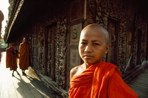 Ein junger Novizenmönch vor geschnitzten Teakholztafeln. Shwenandaw-Kloster, Mandalay, Burma. von James L Stanfield