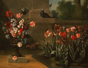 Tulpenbeet und Blumenvase am Fuß einer Mauer