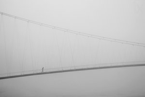 Einsamer Spaziergang auf nebliger Brücke