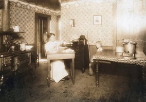 Frau, die Borsten in Zahnbürsten in ihrer Küche einsetzt, ca. 1912