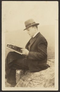 [Mann liest auf einem Felsen eine Zeitschrift] von Louis Fleckenstein