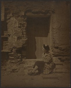 [Frau sitzt vor einem verfallenden Gebäude] von Louis Fleckenstein