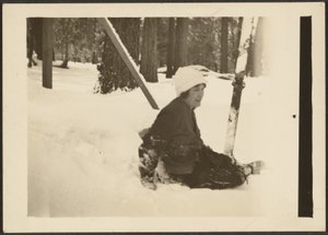 Frau, die im Schnee sitzt