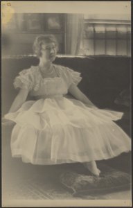 Frau im Chiffonkleid auf Sofa sitzend von Louis Fleckenstein