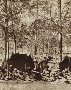 Australische Aborigines, die sich hinter einem Windschutz verstecken von Photographer Australian