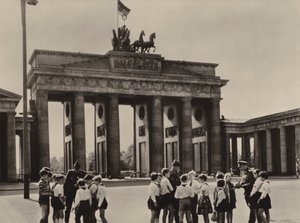 Junge Pioniere kommen zum Brandenburger Tor, dem Wahrzeichen Berlins, um ihre Freunde, die Grenzschutztruppen, zu sehen (s/w Foto) von Photographer German