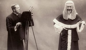 Ein Mann in Soutane richtet die Linse seiner Kamera auf einen Mann, der wie ein Papst gekleidet ist