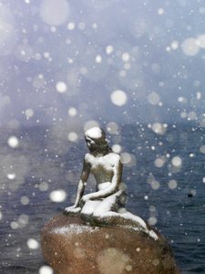 Schneesturm auf der Statue der kleinen Meerjungfrau von Edvard Eriksen, Winter in Kopenhagen, Dänemark, 2022 (Foto) von Sisse Brimberg