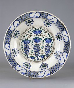 Ein Iznik-Keramikteller, mit einem zentralen Rundel, das drei Traubenbündel und Weinblätter darstellt, ca. 1570