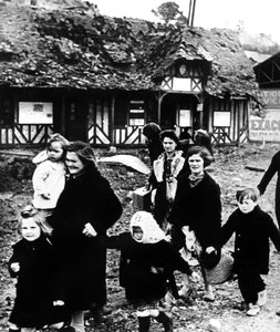 Familien verlassen ihr bombardiertes Dorf während der Landung in der Normandie, Frankreich, 1944