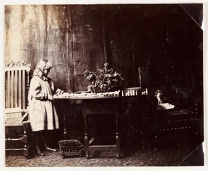 Mädchen spielt mit einer Noahs-Arche-Spielzeugset, um 1905