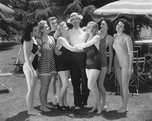 Hollywood, Kalifornien: ca. 1935 Sieben junge Frauen in Badeanzügen wetteifern um die Aufmerksamkeit eines einzelnen Mannes. (s/w Foto)