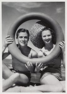 Mann und Frau schauen durch einen Gummiring am Strand, um 1935