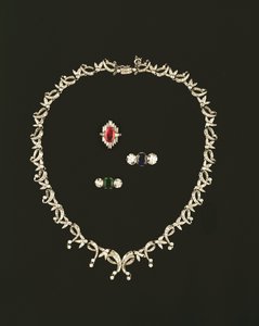 Art-Deco-Halskette mit Scroll- und Blattdesign; Rubin- und Diamant-Baguette-Cluster-Ring; Saphir- und Diamant-Dreistein-Ring; Smaragd- und Diamant-Dreistein-Ring