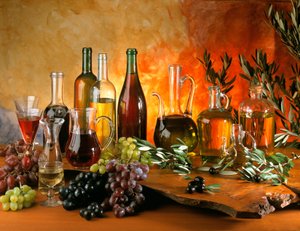 Diät: Stillleben mit Weinkaraffen, Traubenbündeln, Ölflaschen und Oliven. von William M. Timlin