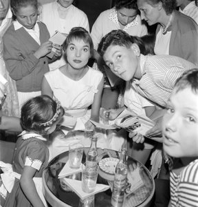 Die Schauspielerin und Model Elsa Martinelli beim XVIII. Internationalen Filmfestival in Venedig Lido (sie gibt jungen Fans Autogramme. Auf dem Tisch eine Flasche Schweppes) - 1957