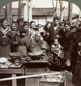 Ein Straßenkünstler mit einem Affen, der die Menge unterhält, Kobe, Japan, 1896