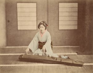Japanische Frau spielt Koto