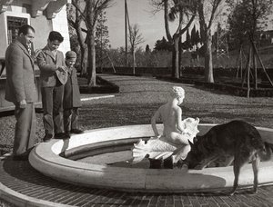 Gino Bartali mit zwei Kindern und einem Hund in der Nähe eines Brunnens