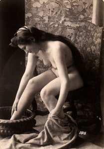 Porträt einer nackten Frau, die ihre Füße wäscht von Unknown photographer