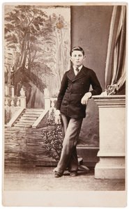 Studio-Porträt eines jungen Mannes vor gemaltem Hintergrund mit Treppe und Garten von William Bentley