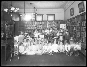 Gruppenporträt von Kindern im Lesesaal einer nicht identifizierten Filiale der Queens Borough Public Library, um 1910 von William Davis Hassler