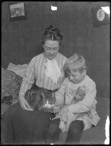 Harriet E. Hassler und William Gray Hassler, sitzend mit getigerter Katze (Reddy) und Teddybär, ca. 1911