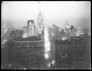 Hochwinkelige neblige Nachtansicht von Lower Manhattan nach Norden, mit dem Singer Building, Woolworth Building und Municipal Building sichtbar, um 1913 von William Davis Hassler