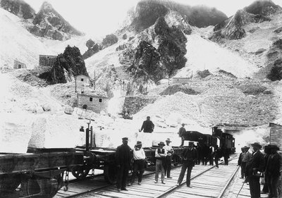 Ausgräber vor einem Eisenbahnzug, beladen mit Marmorblöcken in Ravaccione, in den Apuanischen Alpen von A. Corsini