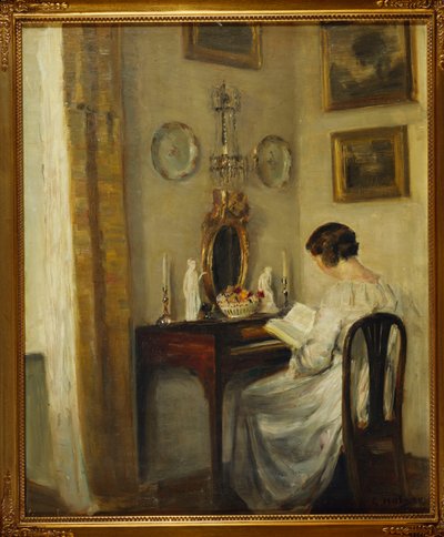 Ein Interieur mit einem Mädchen, das an einem Schreibtisch liest von Carl Holsoe
