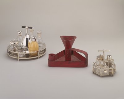 Versilbertes Menageset, Elkington & Co., 1885; rot verzinnte Eisen-Dreieck-Tropfschale, Richard Perry, Son & Co., ca. 1876; versilbertes Menageset, Hukin & Heath, 1885 von Christopher Dresser