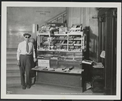Blinder Zeitungsverkäufer, John Martie, an seinem Stand am südlichen Ende des Municipal Building, New York von Company Byron