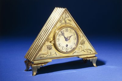 Eine dreieckige Messing-Tischuhr mit gravierter Blumendekoration von Dagobert (attr. to) Peche