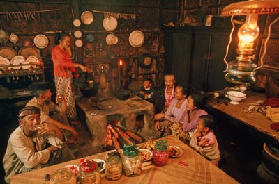 Eine Familie sitzt vor dem Abendessen zusammen. Tenggeresen, Java, Indonesien. von Dean Conger
