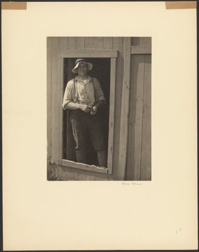 [Mann mit Strohhut in der Tür einer Scheune, der einen Tabakbeutel hält] von Doris Ulmann
