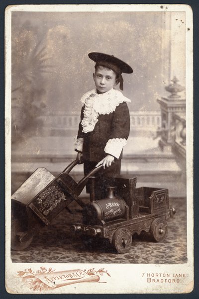 Junge mit Spielzeugzug und Schubkarre von English Photographer