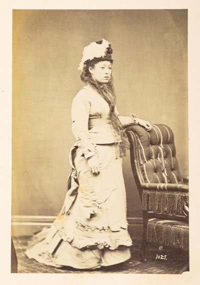 Japanische Frau in europäischer Kleidung, Ganzkörper-Studio-Porträt einer jungen japanischen Frau in westlicher Kleidung und Hut, Fotograf: Unbekannt, Lucas Sammlung: Fotografischer Bericht der Weltreise von Charles James und Morton P, Lucas von English Photographer