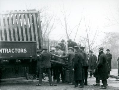 Eine Menschenmenge beobachtet, wie ein Nashorn von einem Lastwagen entladen wird, London Zoo, 1924 von Frederick William Bond