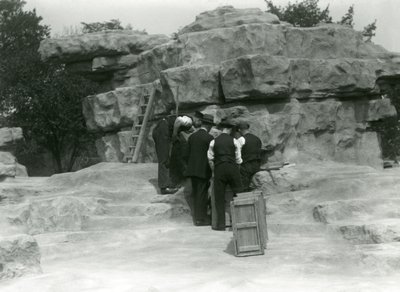Eine Gruppe von Wärtern packt heilige Paviane zwischen den Felsen des 
