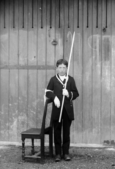 Erstkommunikant, im weißen Kostüm und Handschuhen, mit Medaillen, Rosenkranz, weißer Spitzenmanschette und einer sehr langen Kerze, nahe Bourmont in Haute-Marne, um 1880. Fotografie. Ducos-Sammlung von French Photographer