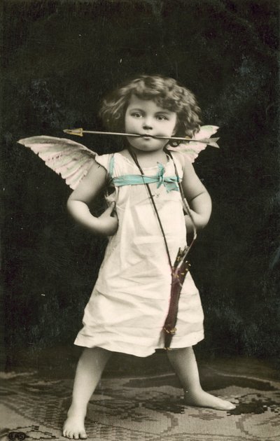 Kleiner Junge, als Amor verkleidet, mit einem Pfeil im Mund von French Photographer