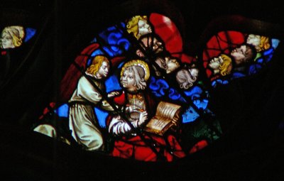 Das westliche Rosenfenster zeigt eine Szene aus dem Buch der Offenbarung: Köpfe der sieben Donner (in einer blauen Wolke) und Johannes wird verboten zu schreiben (10:3-5). von French School
