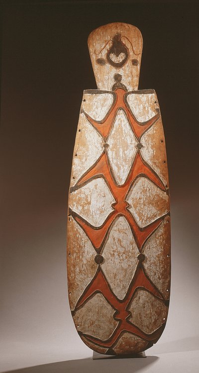 Ovaler Asmat-Schild, geschnitzt mit stilisierten Figuren, eine Maske oben von Guinean New