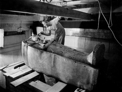 Entdeckung des Grabes von Pharao Tutanchamun im Tal der Könige (Ägypten): Im Grabkammer, Howard Carter arbeitet am Deckel des zweiten Sarges, Oktober 1925, Foto von Harry Burton von Harry Burton